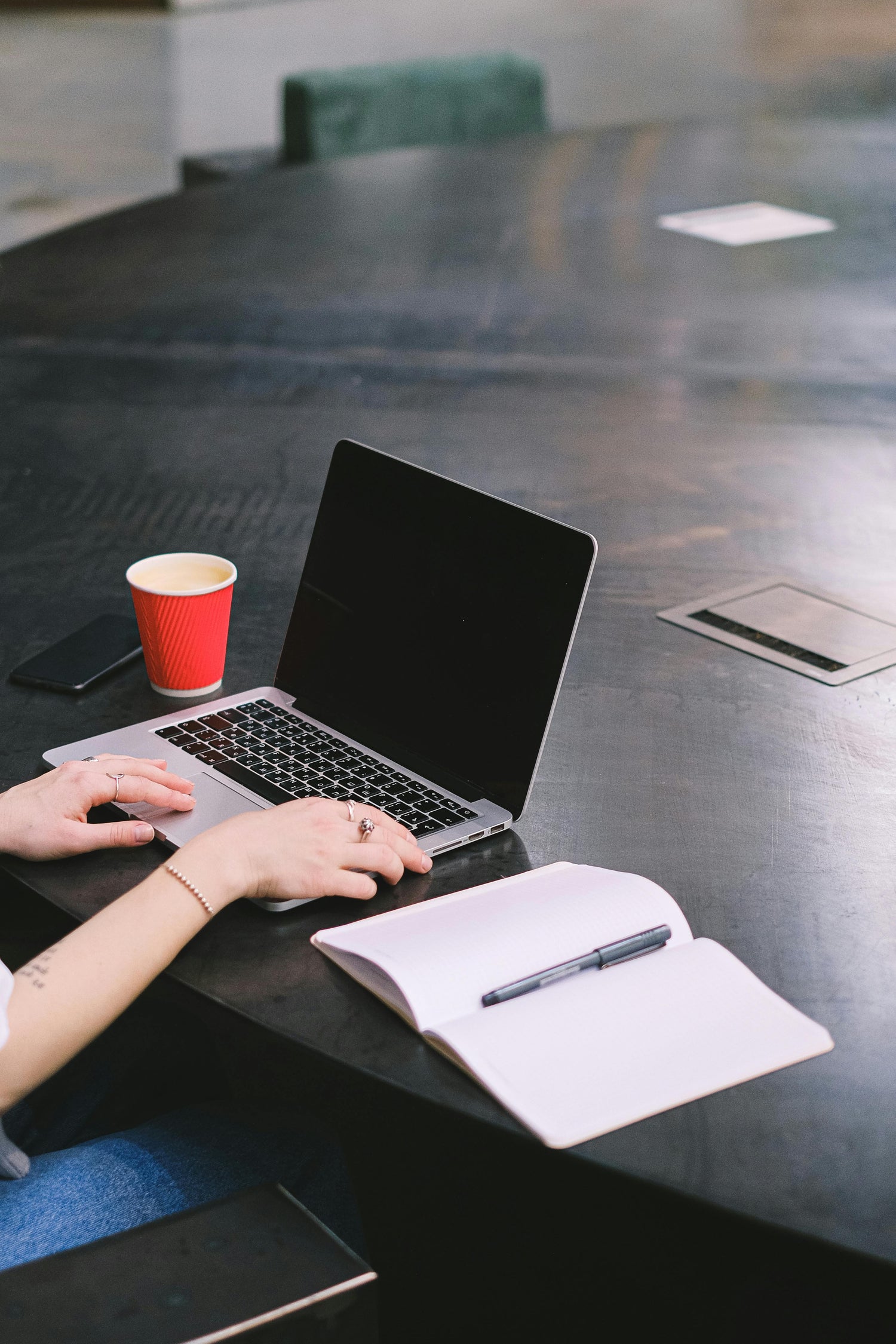Arbeitsplatz mit Laptop, Kaffeetasse und Notizbuch – NutsAndNotes bietet maximale Sicherheit fuer Zugangsdaten.